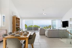 a kitchen and living room with a table and chairs at Thalassa Views Ulladulla in Ulladulla