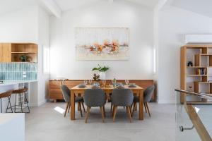 a dining room with a table and chairs at Thalassa Views Ulladulla in Ulladulla +30 photos