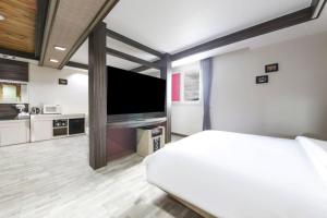 a bedroom with a bed and a flat screen tv at 전주 나비모텔 