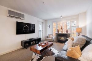 Una sala de estar con un sofá y una chimenea. en Glacier Lodge 216 by Outpost Whistler, en Whistler