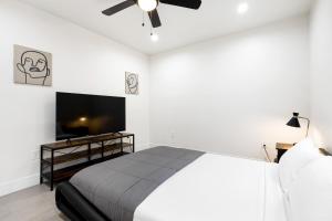 a bedroom with a bed and a flat screen tv at Mid-City Retreat With Backyard And Grill in Los Angeles