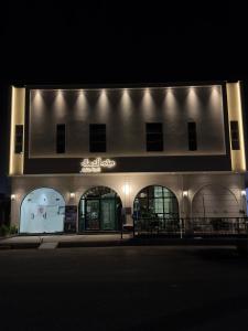 un edificio con un cartel en su costado por la noche en شقة أنيقة دخول ذاتي, en Hail