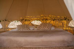 a bed in a tent with two pillows on it at Kitesurf Life Arpoador da Tutoia in Tutóia