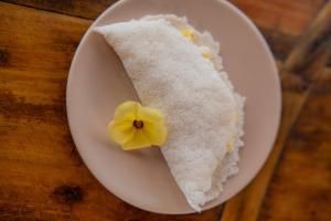 a piece of cake with a yellow flower on a plate at Kitesurf Life Arpoador da Tutoia in Tutóia +34 photos