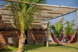 a resort with hammocks in front of a building at Kitesurf Life Arpoador da Tutoia in Tutóia