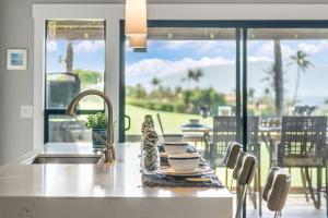 a kitchen counter with a sink and a view of the ocean at Kaanapali Plantation 11 · Modern Luxury Near Beach in Lahaina