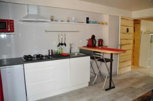 Una cocina con gabinetes blancos y una mesa en ella. en Gite Manzafaro, en Sisteron