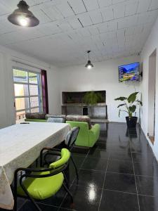 a living room with a table and green chairs at Depto Santa Cruz in Villa Santa Cruz del Lago