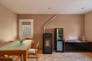 a living room with a table and a refrigerator at Casa Menvil in Sant Jordi de Cercs