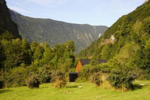 a barn in a field with mountains in the background at Cabañas Refugio Río Roberto in Villa Santa Lucía