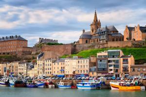 a group of boats docked in a harbor with buildings at Le petit logis in Folligny