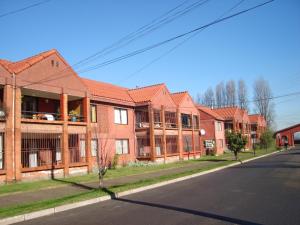 a row of brick apartment buildings on a street at Apart Hotel Punto Real in Curicó