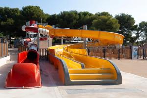 een speeltuin met een gele glijbaan in een park bij Lou Soleil 80 in Carry-le-Rouet
