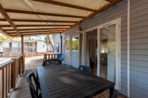 een houten tafel op de veranda van een huis bij Lou Soleil 80 in Carry-le-Rouet