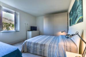 a bedroom with a bed and a window at Il Quartiere apt Pianosa in Pomonte