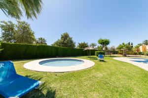 a swimming pool in a yard with a blue chair at Apartamento Naturista Vera playa in Vera