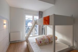 Un dormitorio con una litera y una ventana. en Flaine- Appartement 7 personnes, en Flaine