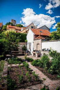a garden in front of a white building with a house at Boutique Hotel Golf Garni in Mikulov
