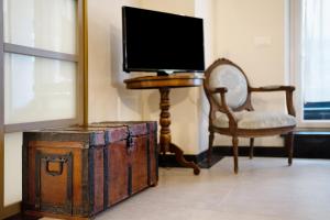 a tv sitting on top of an old trunk with a chair at Inglese, borgo dei pescatori in Cervo