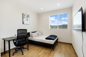 a bedroom with a bed and a desk and a chair at Serenity Condos With Mountain Views in Los Angeles