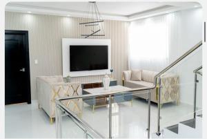 Una sala de estar con un televisor, un sofá y una mesa. en New family villa with a private pool, en Punta Cana