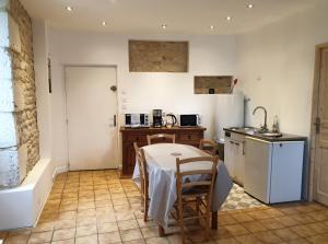 a kitchen with a table and a sink and a table and chairs at Studio 5 - 3 min du Futuroscope in Chasseneuil-du-Poitou