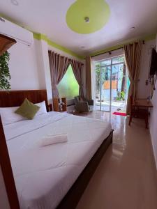 フーコックにあるバンガロー マイ プオン ビンの大きなベッドと大きな窓のある寝室 +70枚の写真