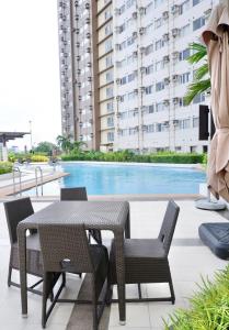 a patio with a table and chairs next to a pool at Urban Oasis in Cagayan de Oro City in Cagayan de Oro