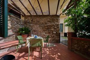 a patio with a table and chairs and a stone wall at Casetta Limone Loft in Gavorrano