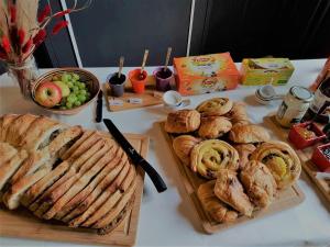 a table with bread and pastries and a bowl of grapes at Chambre Royale au Château de la Rose avec Parking Privé - FR-1-591-766 in Cluis