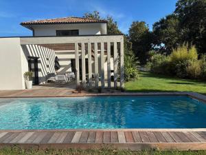 a swimming pool in front of a house at Villa 8 pers à Seignosse avec piscine chauffée et clim - FR-1-791-44 in Seignosse