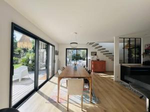 a dining room with a wooden table and glass doors at Villa 8 pers à Seignosse avec piscine chauffée et clim - FR-1-791-44 in Seignosse