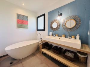a bathroom with a tub and a sink and mirror at Villa 8 pers à Seignosse avec piscine chauffée et clim - FR-1-791-44 in Seignosse +12 photos