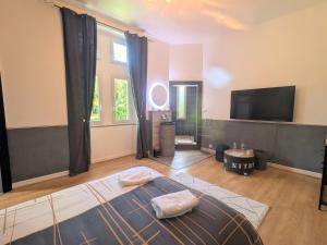 un salon avec un lit et une télévision à écran plat dans l'établissement Suite Familiale au Château avec Balcon sur Parc - FR-1-591-767, à Cluis