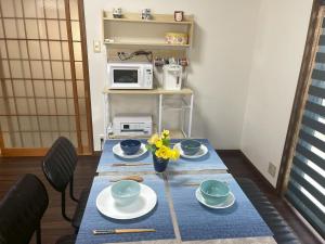 a table with plates and a vase with flowers on it at eyehouse ozu No1 in Ozu