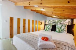 a bedroom with a white bed with flowers on it at Casa Adayeim 1 in Icod de los Vinos +28 photos