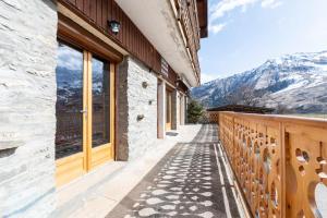 a building with a balcony with a view of mountains at Appartement Albiez Montrond in Albiez-Montrond