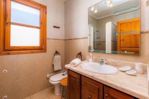 a bathroom with a sink and a toilet and a mirror at Casa Es Domingos in Cala Llombards +22 photos