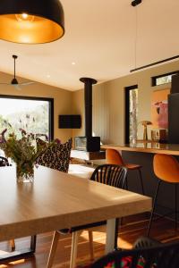 Una sala de estar con una mesa y sillas de madera. en Parachilna at Boardwalk Villas, en Metung