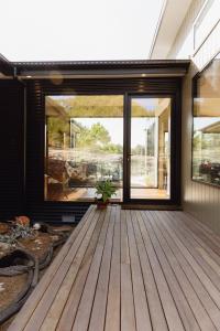 Casa con terraza de madera con puertas correderas de cristal en Parachilna at Boardwalk Villas, en Metung