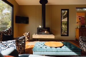 Una sala de estar con un sofá y una chimenea. en Parachilna at Boardwalk Villas, en Metung