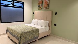 ein kleines Schlafzimmer mit einem Bett mit Fenster in der Unterkunft Arcadia Hotel in Cartagena de Indias