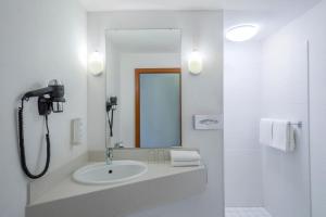 a white bathroom with a sink and a mirror at Hotel Münster Kongresscenter affiliated by Meliá in Münster