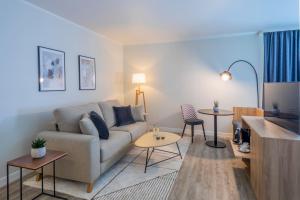 a living room with a couch and a table at Hotel Münster Kongresscenter affiliated by Meliá in Münster