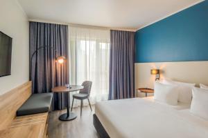 a hotel room with a large bed and a table at Hotel Münster Kongresscenter affiliated by Meliá in Münster +30 photos