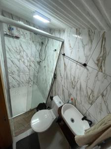 a bathroom with a white toilet and a shower at Casa completa no centro de Belém in Belém