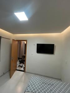a bedroom with a bed and a television on the wall at Casa completa no centro de Belém in Belém