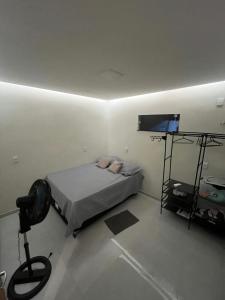 a small bedroom with a bed and a television at Casa completa no centro de Belém in Belém