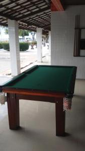 a green pool table sitting in front of a building at Salinas Praia Hotel in Salinas da Margarida