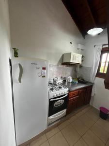 a kitchen with a white refrigerator and a stove at Tu lugar en Santa Clara in Santa Clara del Mar